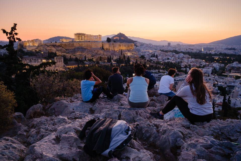 Students watching sunrise at the Hill of the Muses in Athens