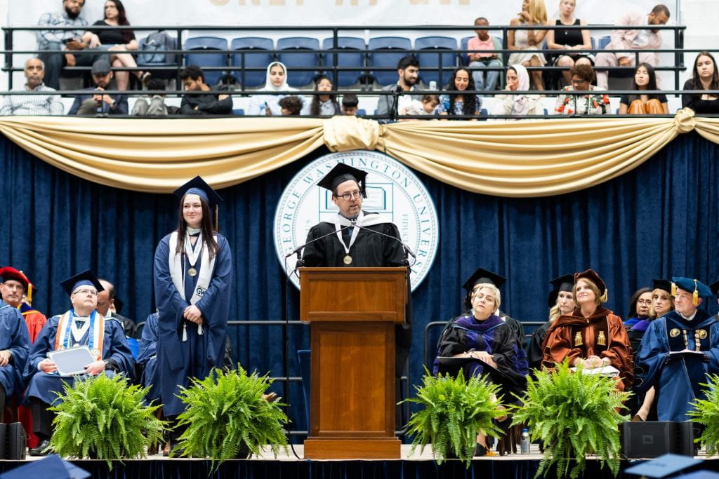 Director John W. Warren introduces Isabella Greene as the CPS Graduate Distinguished Scholar Award at the 2023 CPS Commencement Ceremony.