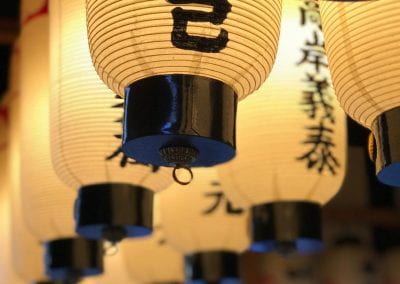 Lines of soft white lanterns glow. They each have a message of calligraphy on them.