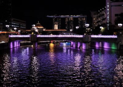 Purple light reflecting on the dark water in Singapore