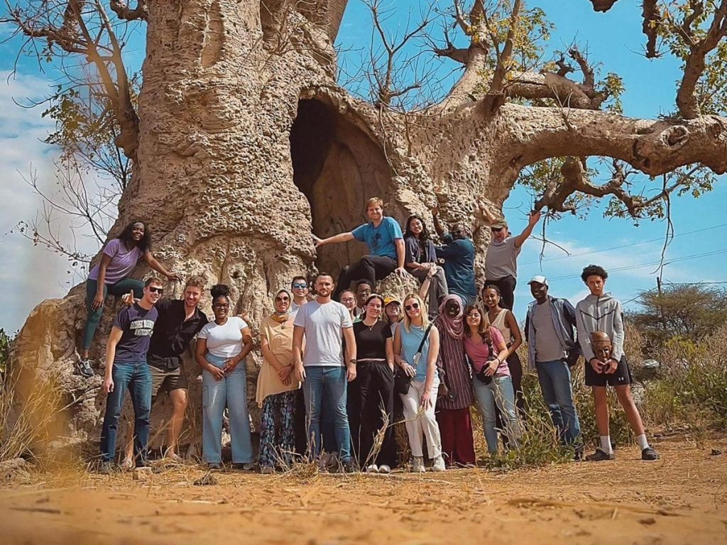 Elliott School of International Affairs students pose at the foot of a historic baobab tree during their trip to Senegal.