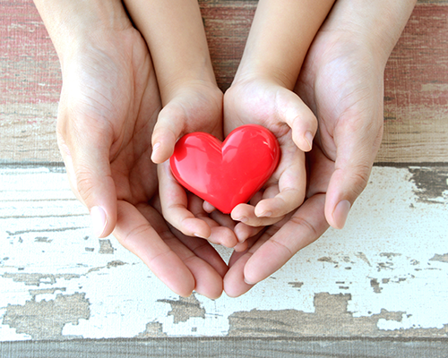 red heart in child and mother's hands