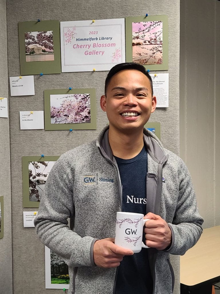 Jeffrey Kai, photo contest winner, with his prize GW cherry blossom mug.
