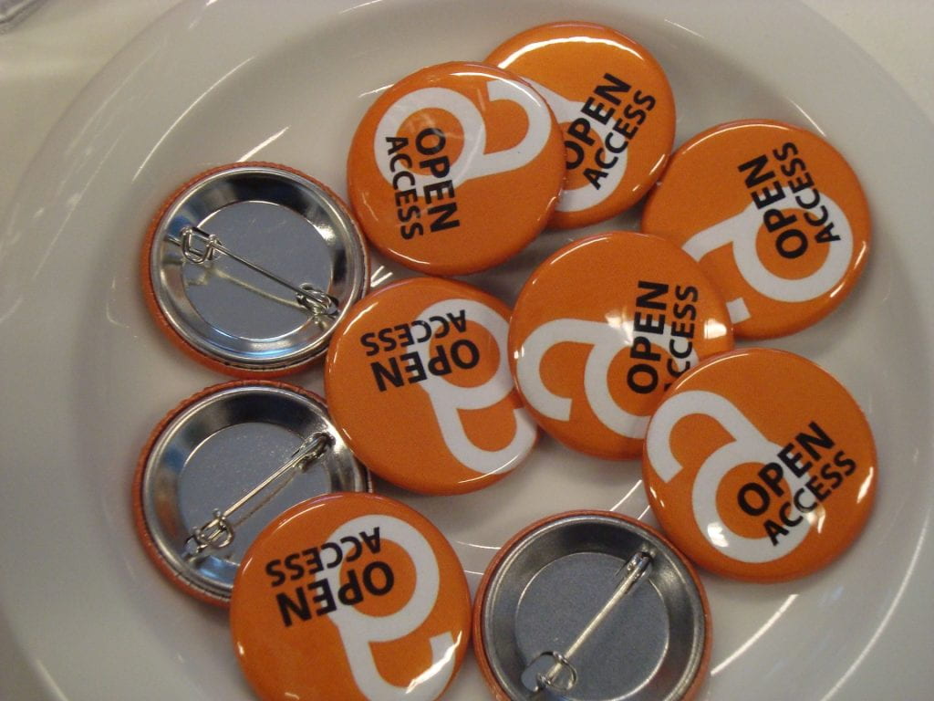 Image of orange buttons with Open Access logo using the letters O and A to form an open padlock in a white bowl.