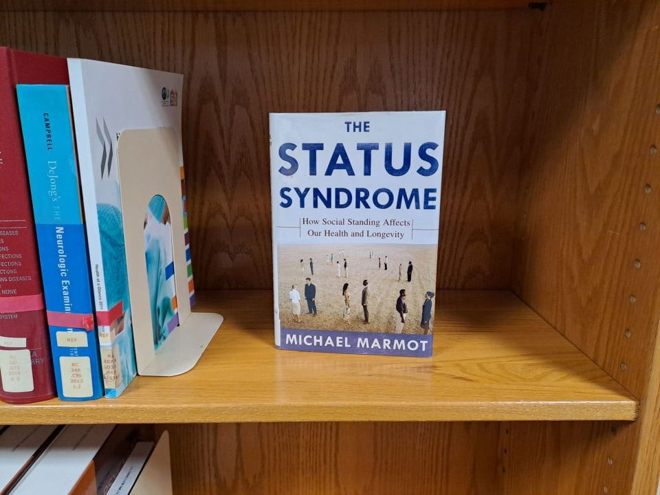 Copy of the Status Syndrome displayed on a shelf.