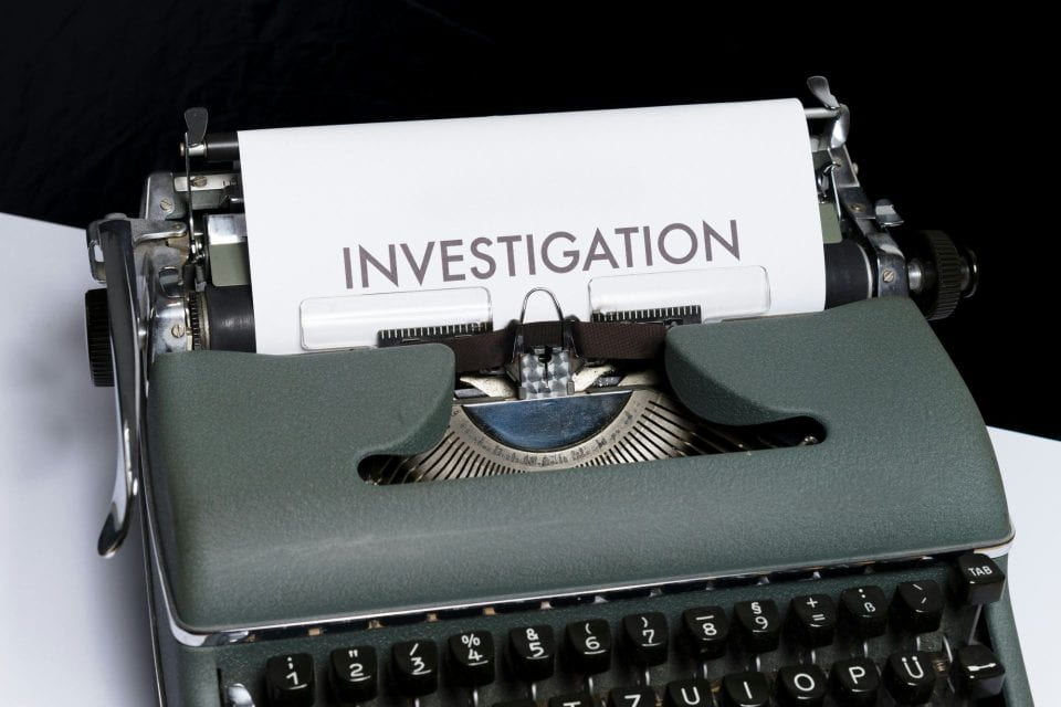 Typewriter with a paper that reads "investigation"