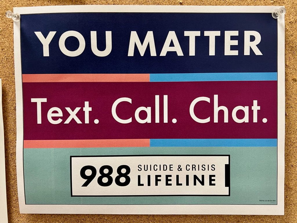 Picture of a sign that says "You Matter. Text. Call. Chat. 988 Suicide & Crisis Lifeline."