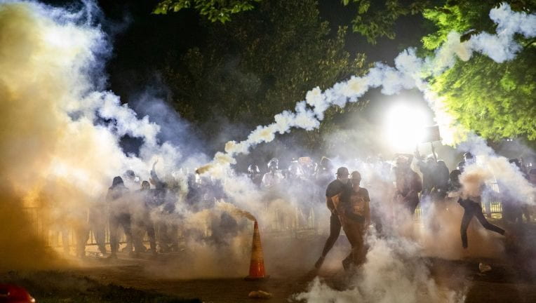 police shooting tear gas into a crowd of peaceful protesters
